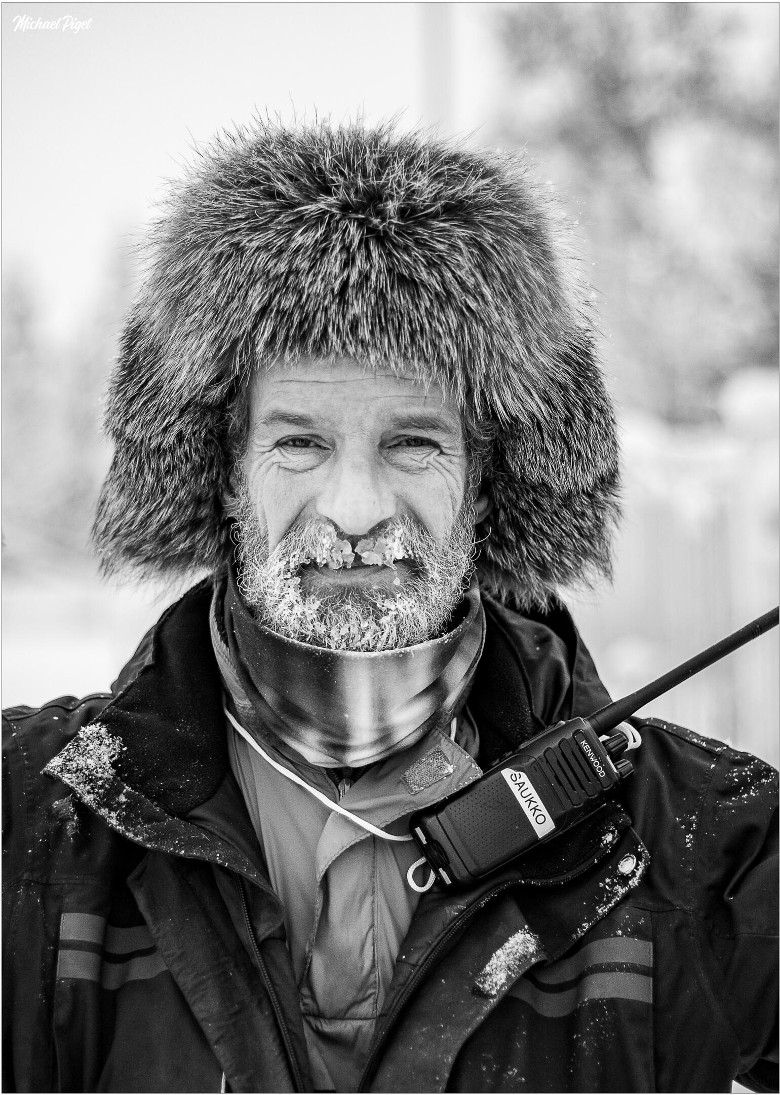 Portrait en noir et blanc d’un homme au visage couvert de givre sous un froid intense